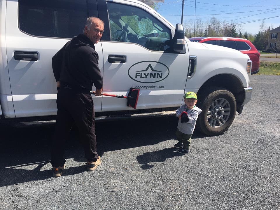 A child giving a Flynn crew member help cleaning the service truck