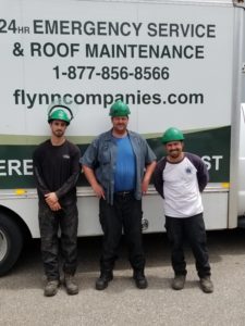 Three construction workers in front of box truck